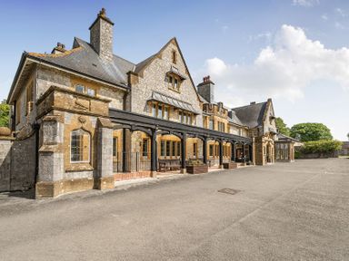 A building with stone details and multiple windows at Harcombe House Accessible Pet Free Bungalow Sleeps 5 Chudleigh