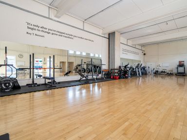 A gym with weights and exercise machines at Harcombe House Accessible Pet Free Bungalow Sleeps 5 in Chudleigh