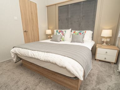 A bedroom with a double bed bedside tables and lamps at Loluke Lodge on The Lake 5 Coniston Drive Borwick near Carnforth