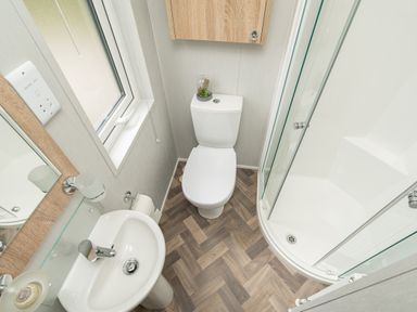 A bathroom with a toilet sink shower and window at Loluke Lodge on The Lake 5 Coniston Drive Borwick near Carnforth