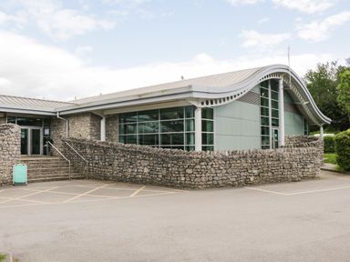 An exterior building with curved roof stone walls and glass windows at Loluke Lodge on The Lake 5 Coniston Drive Borwick near Carnforth