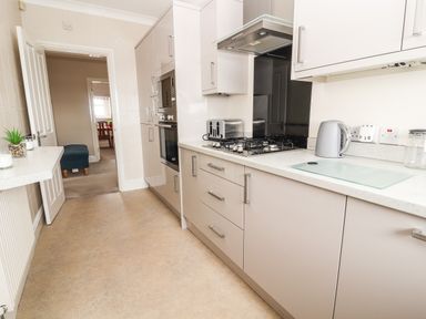 A kitchen with a stovetop toaster kettle and microwave oven at Ty Uchaf in Rhyl