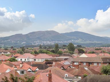 A view of houses with tiled roofs and a mountain in the background at Ty Uchaf in Rhyl