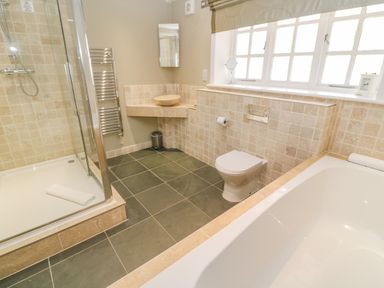 A bathroom with a shower enclosure a bathtub a toilet and a sink at Bodmin Country House in Lanivet