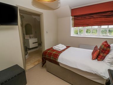 A bedroom with a single bed next to a window and an ensuite bathroom at Bodmin Country House Lanivet
