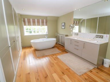 A bathroom with a freestanding bathtub and double sink vanity at Bodmin Country House in Lanivet