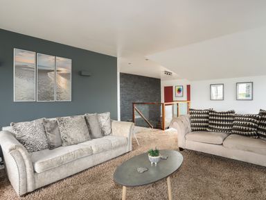 A living room with two sofas and a coffee table on a carpeted floor at The Old Coal Yard in Cemaes Bay