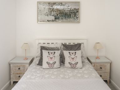 A bedroom with a double bed and two bedside tables with lamps at The Old Coal Yard in Cemaes Bay