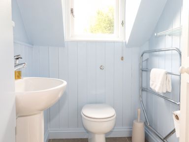 A bathroom with a sink toilet towel rack and window at Huntingstile Lodge in Grasmere