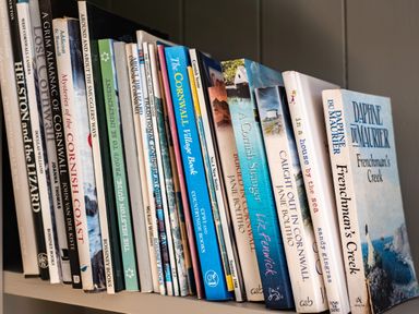 A close-up of a bookshelf with various books about Cornwall and novels at Chi Lowarth in Porthleven