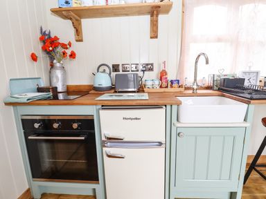 A kitchen with an oven refrigerator sink kettle and toaster at Honeybee Lodge Stixwould near Woodhall Spa