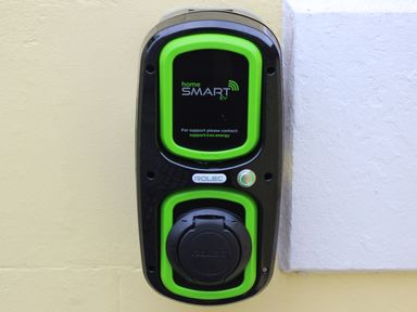 An electric vehicle charging point mounted on a wall at Ty Biwmares in Beaumaris