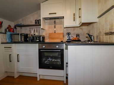 A kitchen with a microwave oven toaster coffee machine sink and cabinets at Periwinkle Atlantic Highway near Bude