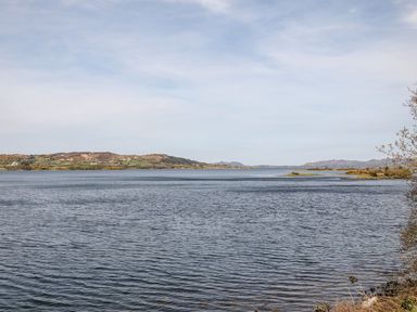 A body of water with distant hills and scattered houses at Bridgetown Cottage in Kerrykeel County Donegal