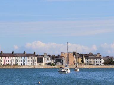 A coastal view with boats on water and a row of houses along the shore at Amelie Cottage in Beaumaris Anglesey