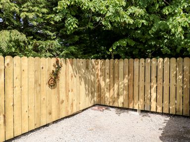 A wooden fenced corner in a garden with a colorful lizard decoration on the fence at Glebe Farm Cottage in Rathfriland County Down