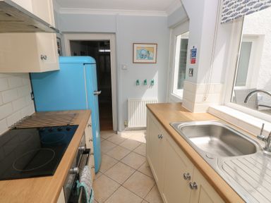 A kitchen with a blue refrigerator and stainless steel sink at Longmoor in Tenby