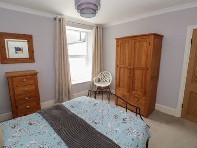 A bedroom with a bed and wardrobe at Longmoor in Tenby