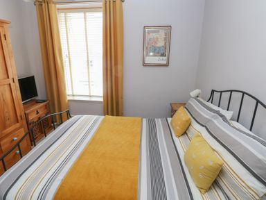 A bedroom with a bed and television at Longmoor in Tenby