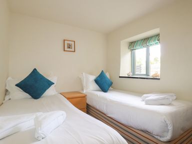 A bedroom with two single beds and a window at Oyster Atlantic Highway near Bude