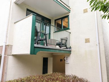 A balcony with two chairs and a table outside a building at Bluebell Hill in Bowness-On-Windermere