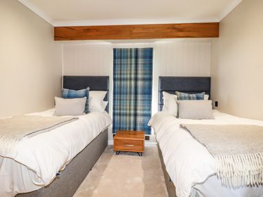 A bedroom with two single beds separated by a wooden nightstand at Atlantic Lodge Atlantic Highway near Bude
