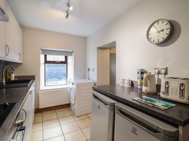 A kitchen with a washing machine and refrigerator at Bridgeway House in Blaenau Ffestiniog