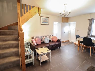 A living room with a sofa and staircase at Bridgeway House in Blaenau Ffestiniog