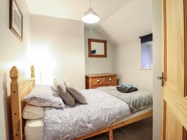 A bedroom with a bed and dresser at Bridgeway House in Blaenau Ffestiniog