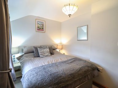 A bedroom with a bed and lamp at Bridgeway House in Blaenau Ffestiniog