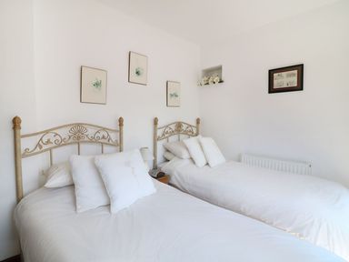 A bedroom with two single beds with metal headboards and white bedding at The Corn Tallet in Westleigh near Bideford
