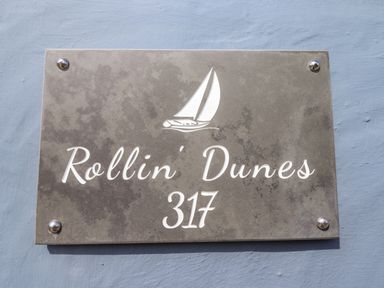 A house number sign with a sailboat graphic and the text Rollin Dunes 317 on a wall at Rollin Dunes in Humberston Lincolnshire