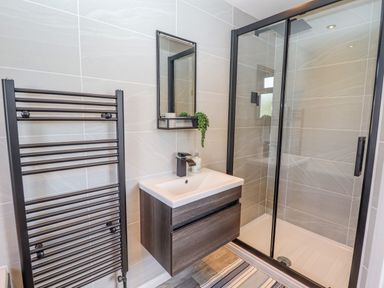 A bathroom with a shower enclosure sink with cabinet mirror and heated towel rail at Rollin Dunes in Humberston Lincolnshire