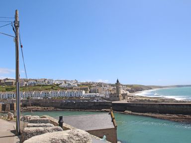 A coastal town with houses and a clock tower near the sea at Wood Brook Cottage in Crowan