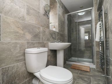 A bathroom with a toilet sink shower and towel rack at Beaconsfield Cottage in Burniston near Scalby