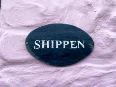 An oval black sign with white text reading SHIPPEN on a textured pink wall at The Shippen @ Canllefaes Penparc near Cardigan