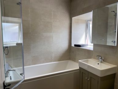 A bathroom with a bathtub sink cabinet and window at The Shippen @ Canllefaes Penparc near Cardigan