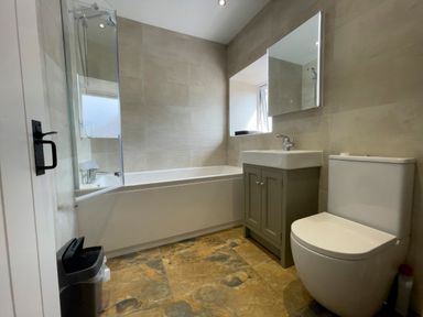 A bathroom with a bathtub shower sink vanity mirror and toilet at The Shippen @ Canllefaes in Penparc near Cardigan