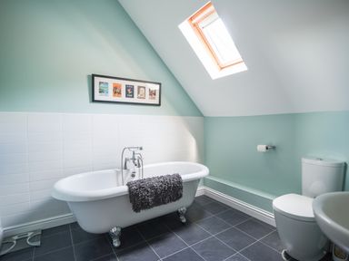 A bathroom with a freestanding bathtub toilet and skylight at 12 The Gardens in Rousdon