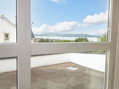 A view of a flat rooftop and distant hills through a window at 12 Hillview Ludden near Buncrana