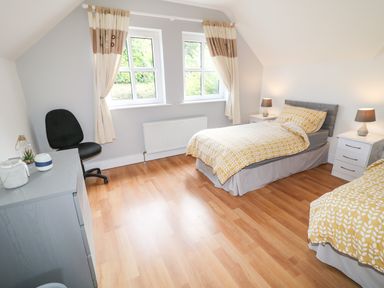 A bedroom with two single beds and bedside tables with lamps at 12 Hillview in Ludden near Buncrana