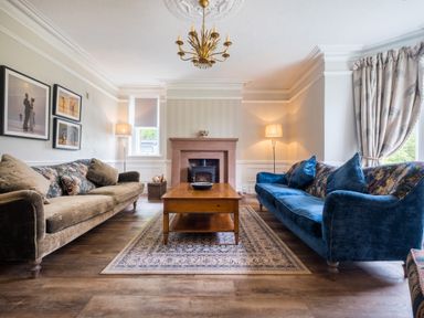 A living room with two sofas a wooden coffee table and a fireplace at Swinside Lodge in Newlands Valley near Keswick