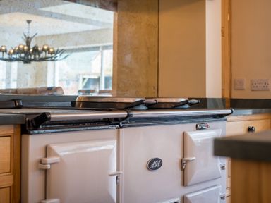 A close-up of an Aga cooker in a kitchen with wooden cabinets at Swinside Lodge in Newlands Valley near Keswick