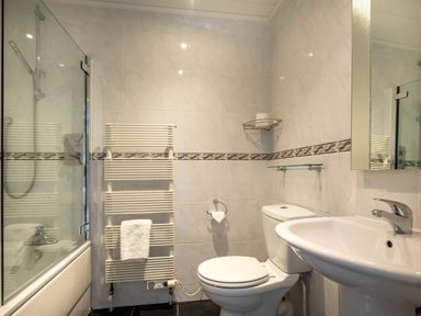 A bathroom with a shower bathtub radiator towel toilet and sink at Swinside Lodge in Newlands Valley near Keswick