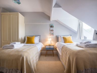 A bedroom with two single beds a bedside table lamp and a wardrobe at Swinside Lodge in Newlands Valley near Keswick