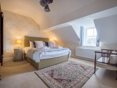 A bedroom with a bed side table lamps and rug at Swinside Lodge in Newlands Valley near Keswick