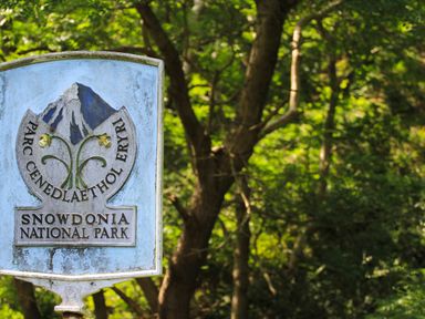 A sign for Snowdonia National Park with trees in the background at Haddef Penmaenmawr in Penmaenmawr