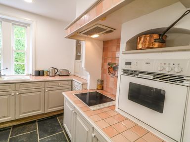 A kitchen with white cabinets cooking stove oven and a copper pan on a shelf at Scarvagh House in Scarva near Loughbrickland