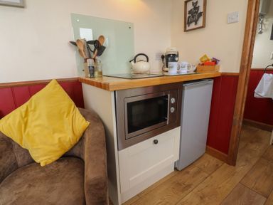 A kitchen area with a microwave and kettle at The Journeyman Luxury Shepherds Hut in Barnoldswick