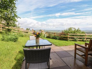 An outdoor area with a table and chairs at The Journeyman Luxury Shepherds Hut in Barnoldswick